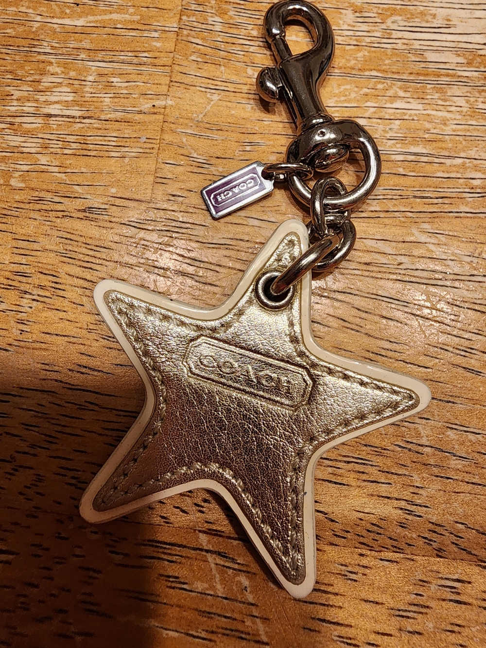 vintage Coach star-shaped leather keychain featuring a metallic gold finish